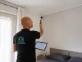 Tecnico con fonometro e tablet esegue misurazioni per insonorizzare una stanza, analizzando l'acustica.