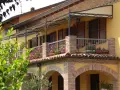 Il montaggio scossalina balcone protegge la facciata. Balcone fiorito con ringhiera in ferro battuto e tettoia decorata.