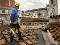 Operaio sul tetto di Firenze, valuta il costo coibentazione tetto esistente. Lavori in quota con vista Duomo.