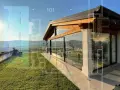 Un moderno **tetto in vetro** si fonde con la natura, mostrando dettagli costruttivi e un panorama collinare.