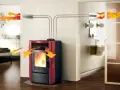 Stufa a pellet rossa con canalizzazione per distribuire il calore in più stanze.
