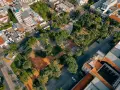 Vista aerea di un parco urbano con palme e alberi, circondato da edifici. Un esempio di come la legge sulla rigenerazione urbana possa trasformare spazi verdi in città.