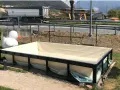 Piscina seminterrata in fase di installazione, con un grande anatroccolo gonfiabile sullo sfondo. Si attendono i permessi per completare il progetto.