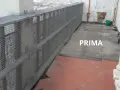 Il balcone è pronto per piastrellare su piastrelle esistenti. Si vedono attrezzi e un secchio, pronti per il lavoro.