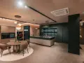 Elegante cucina scura con isola centrale e un tavolo rotondo. Il pavimento chiaro crea un contrasto moderno e luminoso.