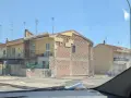 Edificio in fase di ristrutturazione, con facciata parzialmente scoperta che rivela la muratura. Sembra un condominio in attesa del suo nuovo cappotto.