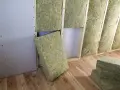 Pannelli di lana di roccia, un isolante calpestabile, vengono installati in una parete in costruzione con struttura in legno e cartongesso.