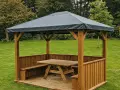Gazebo in legno con tavolo e panche, perfetto per idee gazebo fai da te in giardino.