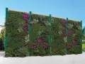 Muro verde fiorito, un'idea per barriere antirumore giardino fai da te. Piante rigogliose e fiori viola creano un'oasi di pace.