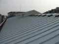Tetto moderno rifatto con pannelli coibentati grigi, con lucernari a vista.