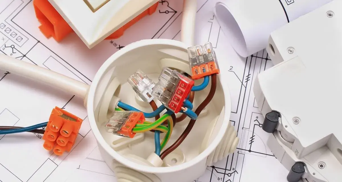 Materiali elettrici su progetto: scatola di derivazione, connettori, cavi e interruttore. Ideale per la comunicazione lavori al vicino.