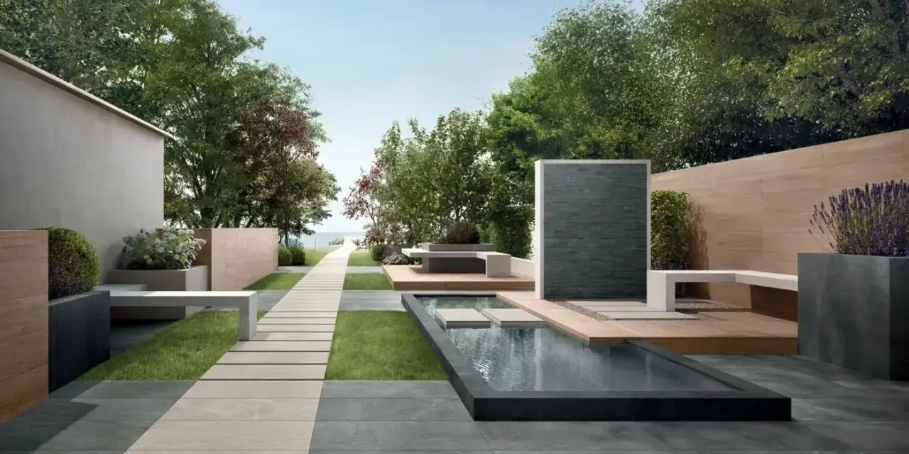 Un elegante giardino con pavimentazione senza cemento, sentiero in pietra, piscina e zona relax.