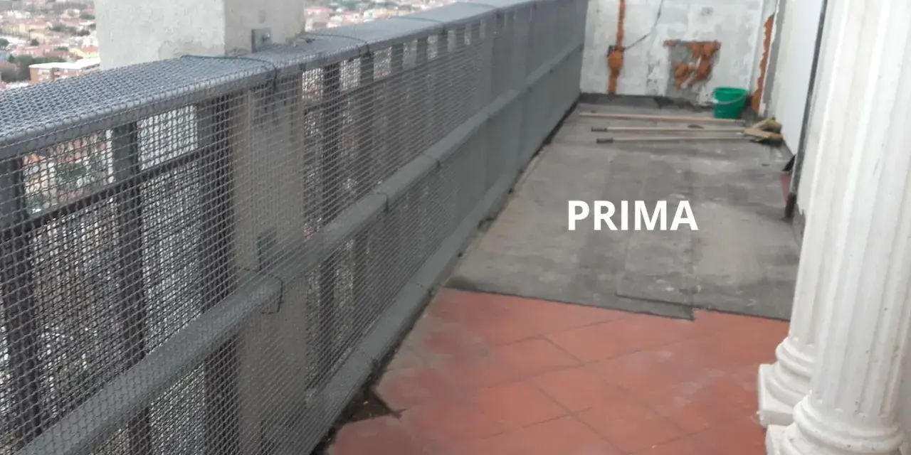 Il balcone è pronto per piastrellare su piastrelle esistenti. Si vedono attrezzi e un secchio, pronti per il lavoro.