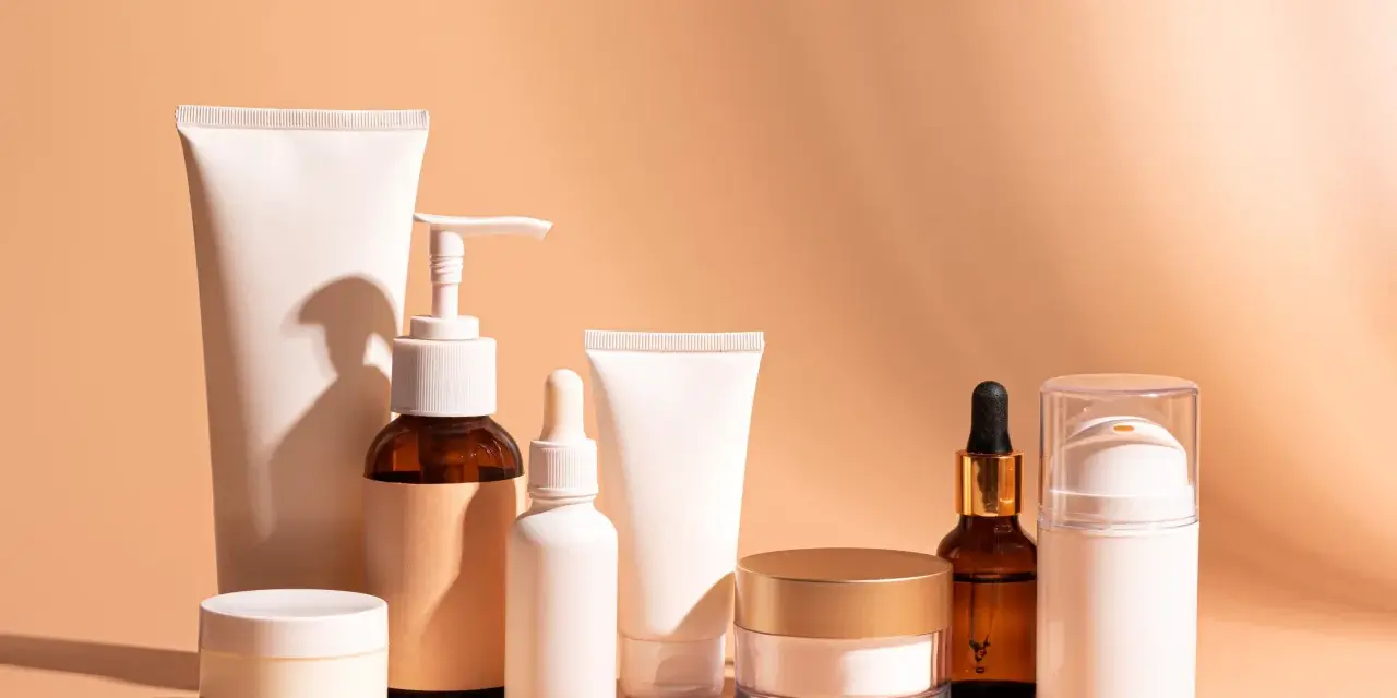 Una collezione di prodotti per la cura della pelle, tra cui creme, sieri e tubetti, ideali come fissativo prima della rasatura per una pelle liscia e protetta.