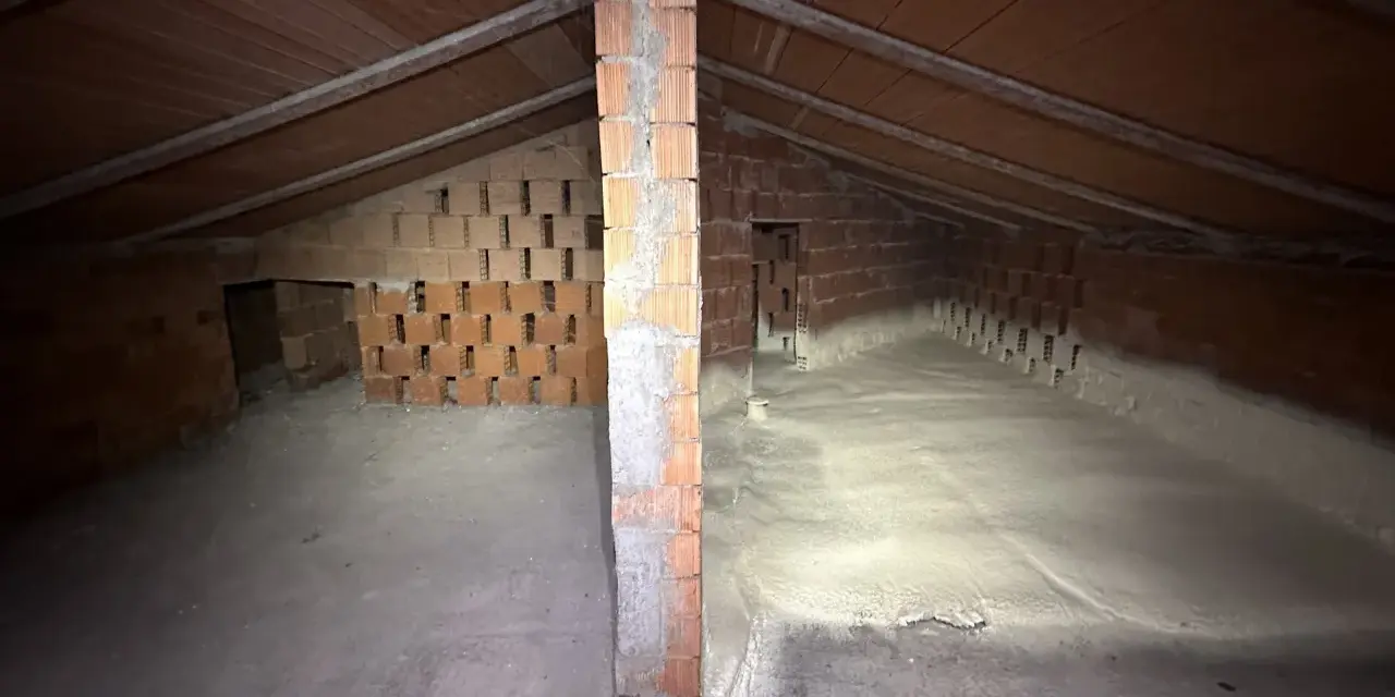 Sottotetto in costruzione con pareti in mattoni e tetto in legno. La lana di roccia a cosa serve? Qui si vede l'isolamento termico e acustico.