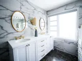 Bagno moderno con marmo, doppio lavabo e rubinetteria oro. Un'idea per capire quanto costa piastrellare un bagno di 5 mq.
