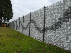 Muro di recinzione moderno con gabioni riempiti di pietre bianche e grigie, creando un motivo ondulato. Ottime idee muri di recinzione per un giardino.