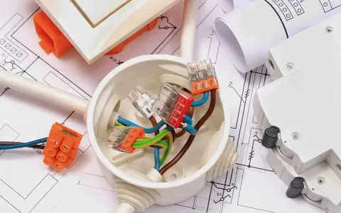 Materiali elettrici su progetto: scatola di derivazione, connettori, cavi e interruttore. Ideale per la comunicazione lavori al vicino.