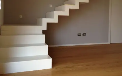 La larghezza scala interna è ben definita da gradini bianchi e minimalisti che salgono verso l'alto.