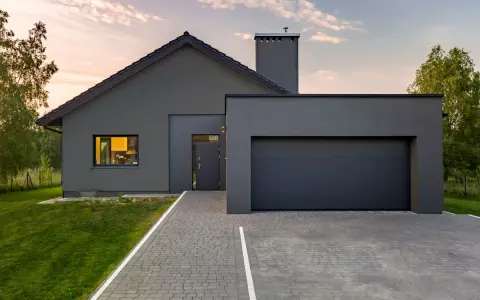 Casa moderna con tetto spiovente e garage, perfetta per un progetto di pitturare esterno casa. Il grigio antracite dona un aspetto elegante.