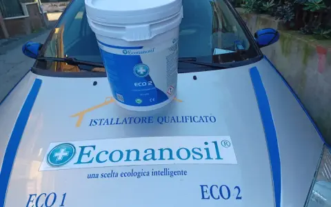 Secchio Econanosil ECO 2, 32 litri, su cofano auto con adesivi "Installatore Qualificato" e "una scelta ecologica intelligente". Scheda tecnica visibile.