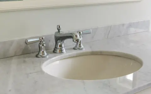 Lavandino in marmo poroso con rubinetteria cromata. Per sapere come pulire il marmo poroso, guarda questo bagno elegante.