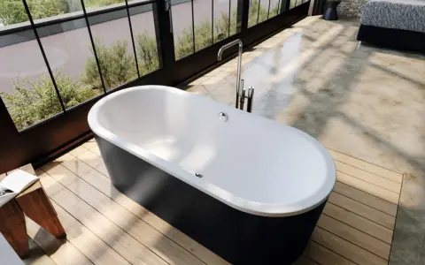 Vasca da bagno freestanding nera e bianca, con rubinetteria a colonna. L'altezza della vasca da bagno in muratura è ideale per un bagno moderno.