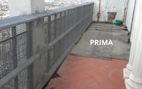Il balcone è pronto per piastrellare su piastrelle esistenti. Si vedono attrezzi e un secchio, pronti per il lavoro.