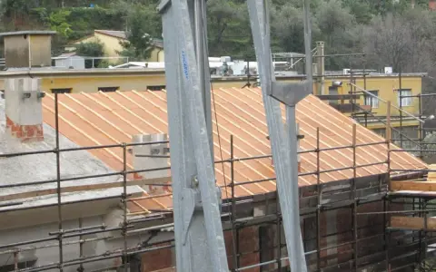 Lavori in corso per l'isolamento tetto laterocemento. Ponteggi e struttura in legno per il nuovo tetto.