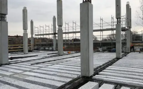 Costruzione in corso con pilastri in cemento e solai prefabbricati in attesa di completamento.