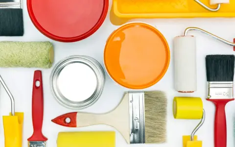 Pennelli, rulli e barattoli di vernice colorata, pronti per dipingere e come evitare i segni del rullo in controluce.