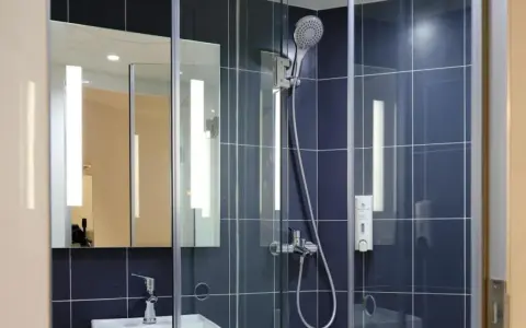 Doccia moderna con piastrelle blu. Valuta il costo sostituzione piatto e box doccia per un bagno rinnovato.