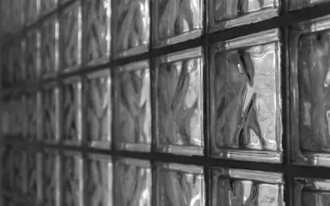 Muro di vetrocemento con texture ondulate. Le misure standard dei blocchi creano un pattern geometrico.