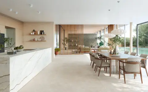 Ampio open space con cucina moderna, isola in marmo e zona pranzo. Pavimenti diversi creano continuità visiva tra gli ambienti.