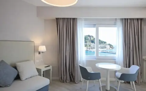 Pavimenti chiari e luminosi, perfetti per idee pavimenti casa al mare. Camera con vista, divano, tavolino e sedie moderne.