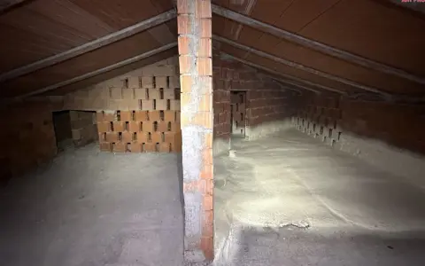 Sottotetto in costruzione con pareti in mattoni e tetto in legno. La lana di roccia a cosa serve? Qui si vede l'isolamento termico e acustico.