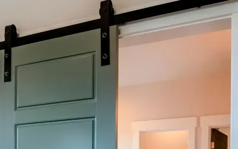Trasformare porta battente in scorrevole: una porta verde acqua con binario nero, un'elegante soluzione moderna per ottimizzare gli spazi.