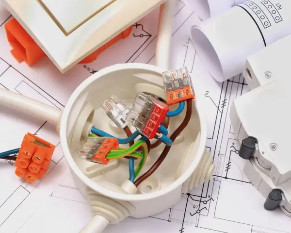 Materiali elettrici su progetto: scatola di derivazione, connettori, cavi e interruttore. Ideale per la comunicazione lavori al vicino.