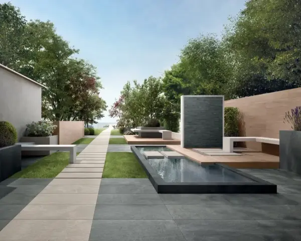 Un elegante giardino con pavimentazione senza cemento, sentiero in pietra, piscina e zona relax.