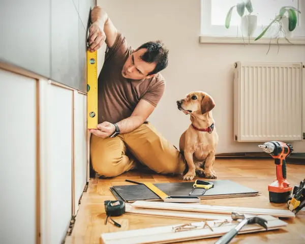 Uomo con cane controlla livellamento per lavori di manutenzione straordinaria detrazione 50.