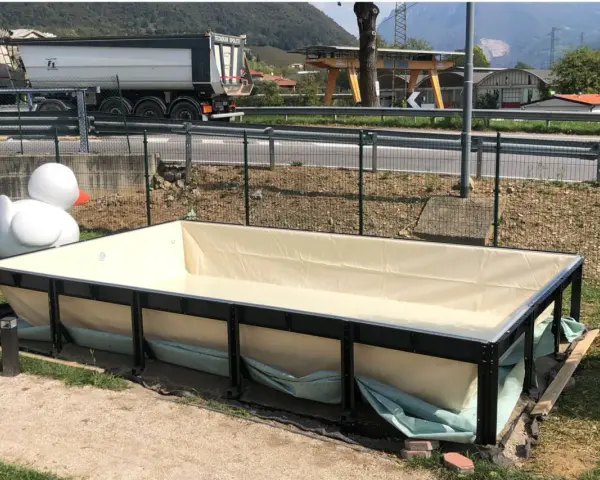 Piscina seminterrata in fase di installazione, con un grande anatroccolo gonfiabile sullo sfondo. Si attendono i permessi per completare il progetto.