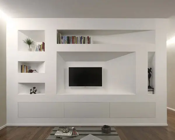 Parete attrezzata moderna con nicchie per libri e TV, realizzata in cartongesso doppia lastra, con mobili contenitori a scomparsa.