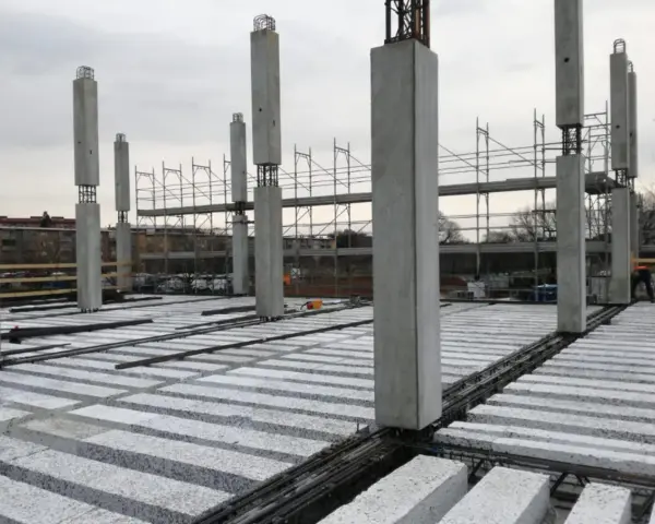 Costruzione in corso con pilastri in cemento e solai prefabbricati in attesa di completamento.