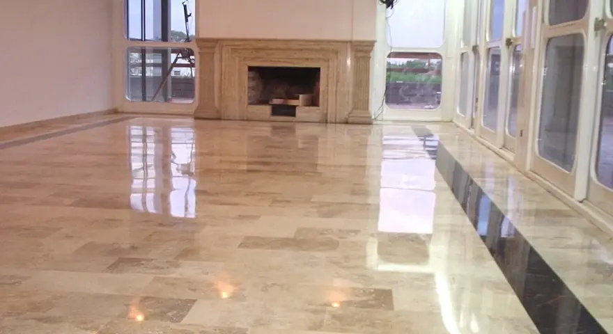 Pavimento in marmo beige con finitura a specchio, che riflette le luci e le finestre. Un lavoro di lucidatura perfetto per un ambiente elegante.