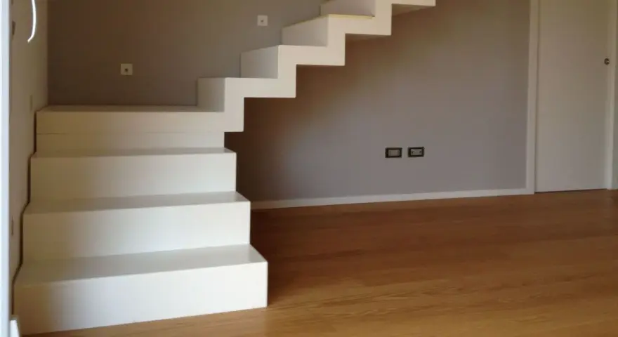 La larghezza scala interna è ben definita da gradini bianchi e minimalisti che salgono verso l'alto.