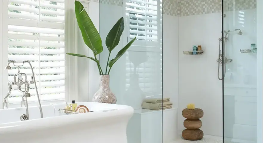 Bagno elegante con vasca freestanding e doccia con ampie dimensioni. Piante verdi e dettagli in mosaico completano l'ambiente.