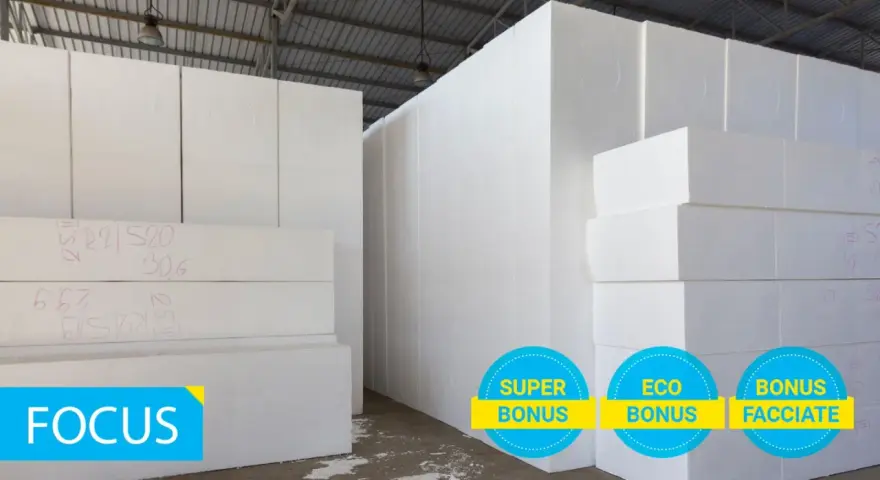 Magazzino con blocchi di polistirolo bianco. La scheda tecnica eps 100 è visibile su alcuni blocchi. Tre cerchi con scritte "Super Bonus", "Eco Bonus" e "Bonus Facciate".
