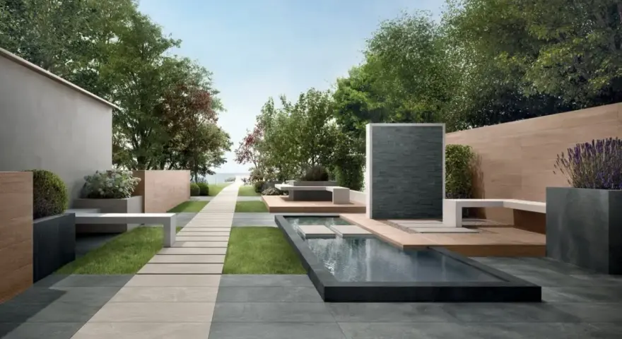 Un elegante giardino con pavimentazione senza cemento, sentiero in pietra, piscina e zona relax.