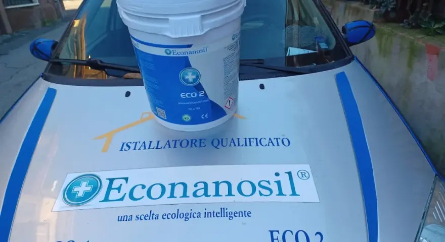 Secchio Econanosil ECO 2, 32 litri, su cofano auto con adesivi "Installatore Qualificato" e "una scelta ecologica intelligente". Scheda tecnica visibile.