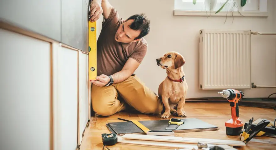 Uomo con cane controlla livellamento per lavori di manutenzione straordinaria detrazione 50.